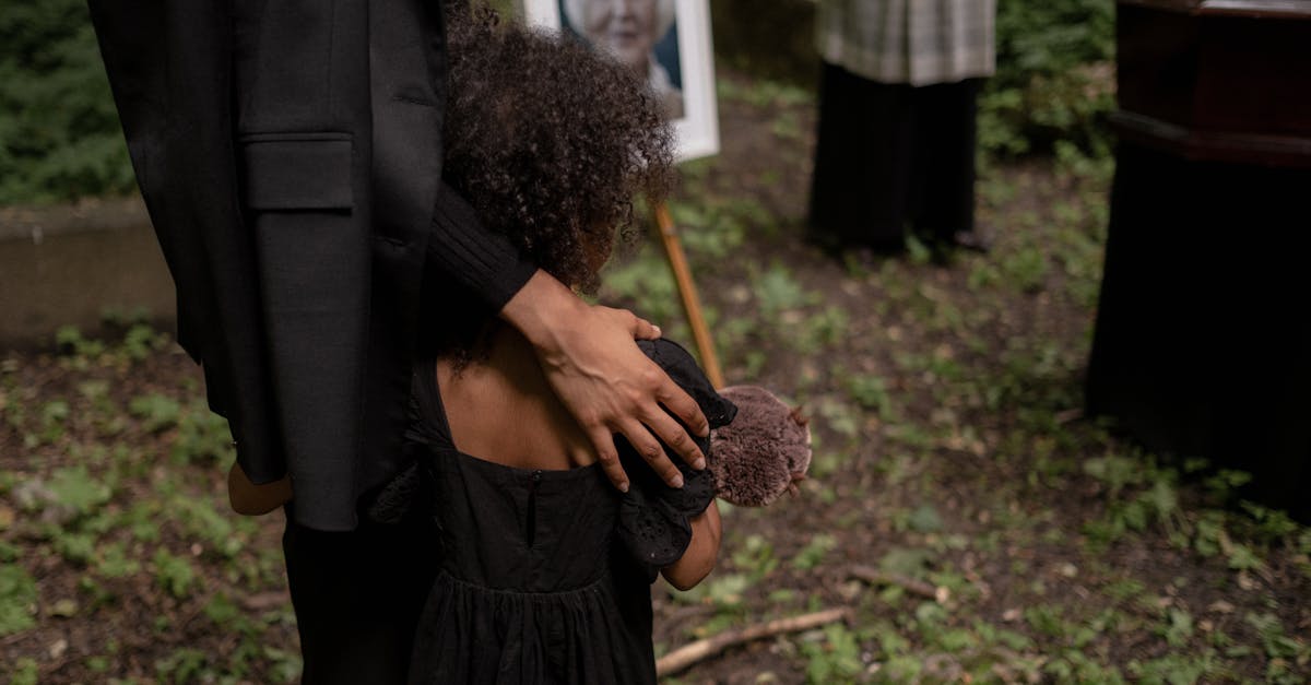 A Child in Black Dress Mourning in the Cemetery