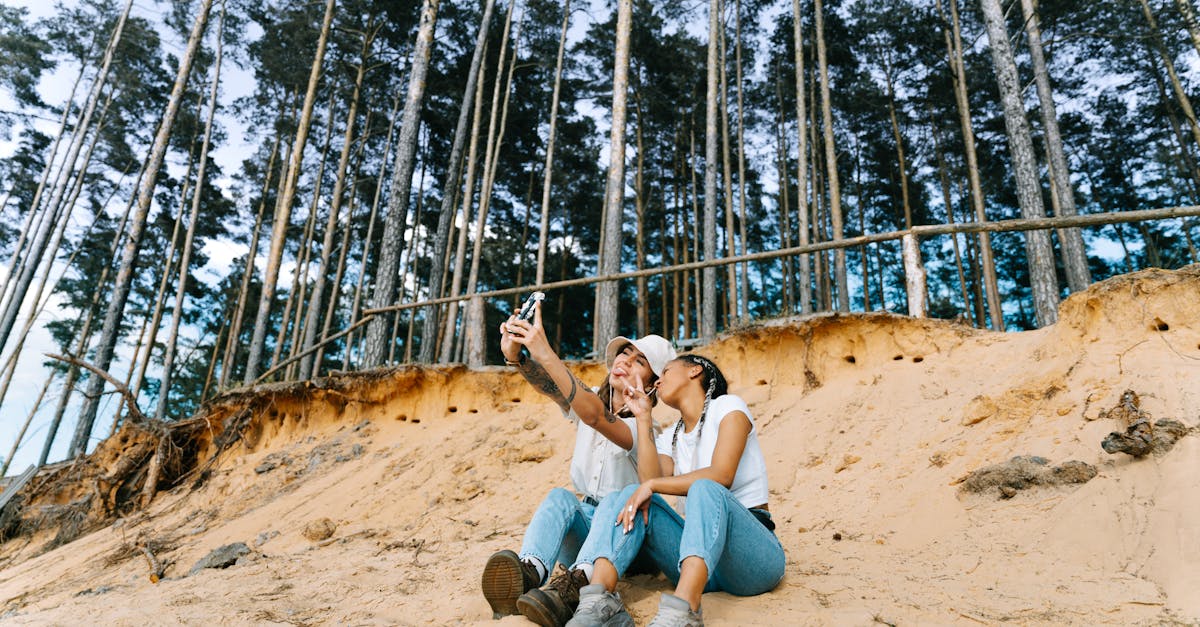 Women Sitting on Beach and Taking Selfie